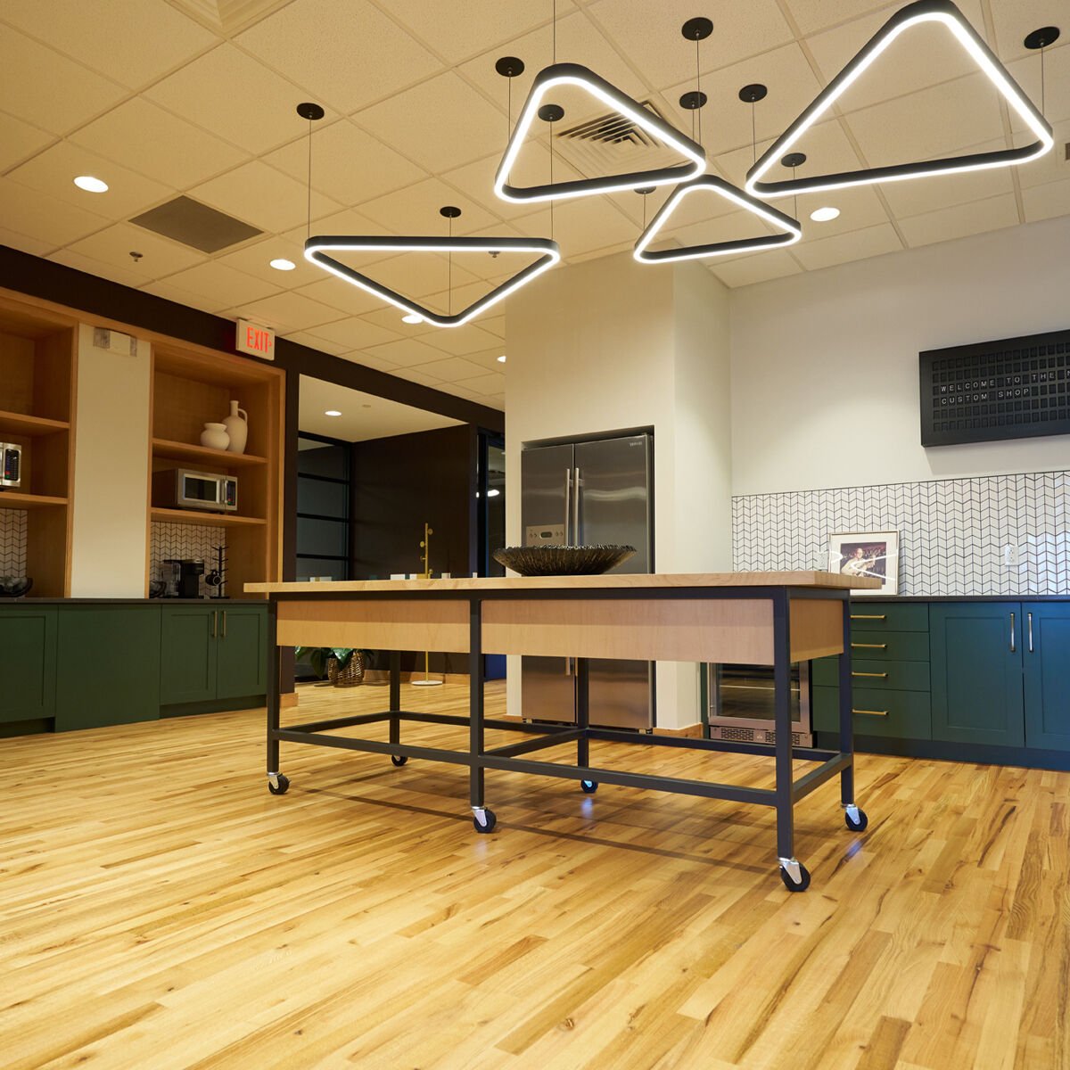 Triangular lights on a ceiling above a hardwood floor